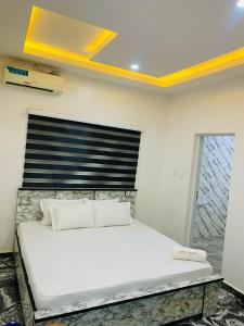 a bedroom with a large white bed in a room at Lazeto Hotel & Resort in Zokoja