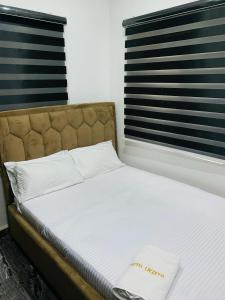 a bed in a room with two windows at Lazeto Hotel & Resort in Zokoja