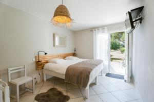 a bedroom with a bed and a sliding glass door at Villa Sarment Oleron in Saint-Pierre-dʼOléron +6 photos