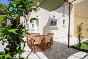 a patio with a table and chairs under an umbrella at Oropion Rental houses in Néa Palátia