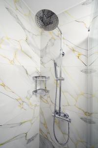 two pictures of a shower in a bathroom at Oropion Rental houses in Néa Palátia +37 photos