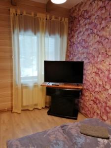 a living room with a flat screen tv on a wall at Viesu māja Liepas in Rēzekne