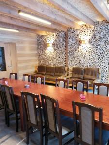 a dining room with a large wooden table and chairs at Viesu māja Liepas in Rēzekne