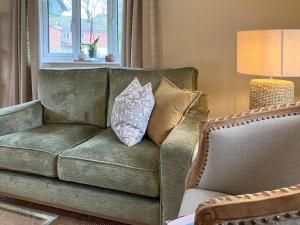 a green couch with a pillow on it in a living room at Pine View - Uk50699 in St Margarets at Cliff