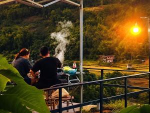 a group of people sitting at a table looking at a waterfall at เวนิสบ้านเวร โดมใส in Ban Khun Nam Nan