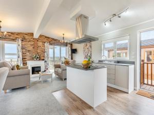 a kitchen and living room with white cabinets and a fireplace at Church View - Uk46896 in Kinlet