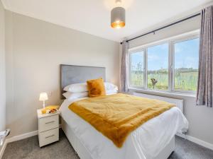 a white bedroom with a bed and a window at Church View - Uk46896 in Kinlet