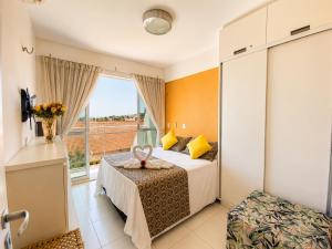 a hotel room with a bed and a window at Apto. Palm Beach, 300M Beach Park in Aquiraz