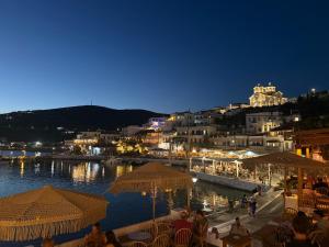 a group of people sitting at a restaurant by the water at night at St Pauls Batsi in Batsi