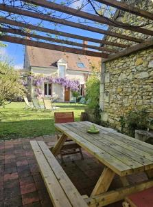 a wooden picnic table in front of a stone building at L'annexe du vigneron in Châtillon-sur-Cher
