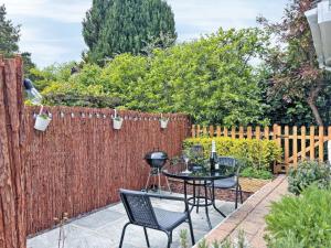 a patio with a fence and a table and chairs at Treetops in Baildon