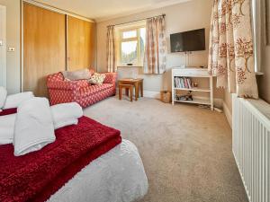 a living room with a red bed and a couch at Treetops in Baildon