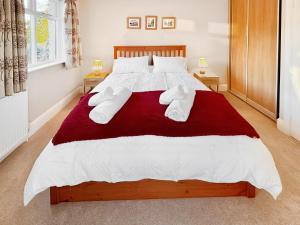 a bedroom with a large bed with white sheets and pillows at Treetops in Baildon