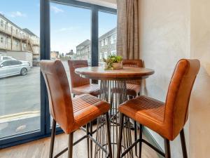 Ein Tisch und Stühle vor einem Fenster in der Unterkunft Flat 1 - Uk49037 in Narberth