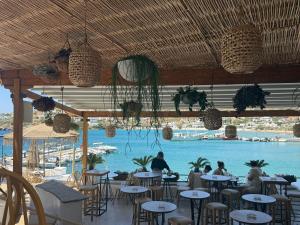 a restaurant with a pool with people sitting at tables at St Pauls Batsi in Batsi