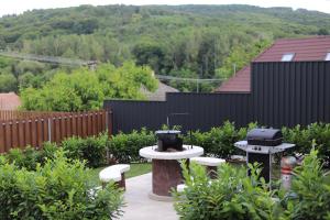 a backyard with a grill and two tables and chairs at Bakony Kincse Vendégház in Jásd