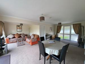 a living room with a table and a couch at Cotehele - B6524 in Saint Cleer +10 photos