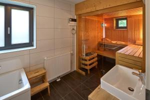 a bathroom with a tub and a sink in it at Chalet Resort Montafon I - Chalets & Chalet-Apartments in Sankt Gallenkirch +203 photos