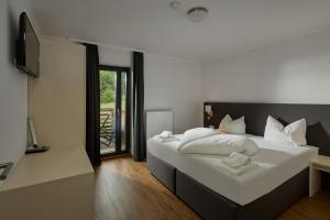 a bedroom with a large white bed with white pillows at Chalet Resort Montafon I - Chalets & Chalet-Apartments in Sankt Gallenkirch