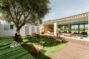 a yard with chairs and a tree and a house at Villa Sarment Oleron in Saint-Pierre-dʼOléron