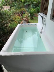 a white bath tub with a pool of water at Cottage Wild Boar in Udawalawe