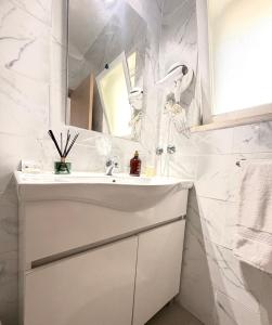 a white bathroom with a sink and a mirror at Retiro dos Batudes in Palmela +49 photos