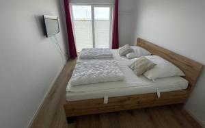 a bed with white sheets and pillows in a room at Ferienwohnung Mövenkieker in Kappeln