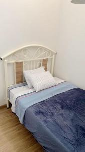 a bedroom with a bed with a white headboard at Apartmento en Chiclayo in Chiclayo