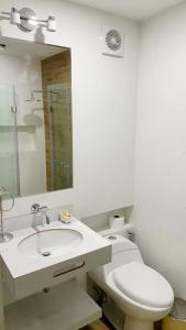 a white bathroom with a toilet and a sink at Apartmento en Chiclayo in Chiclayo