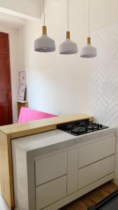 a kitchen with a stove and three pendant lights at Apartmento en Chiclayo in Chiclayo