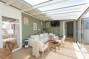 a living room with a white couch and a table at Villa Sarment Oleron in Saint-Pierre-dʼOléron