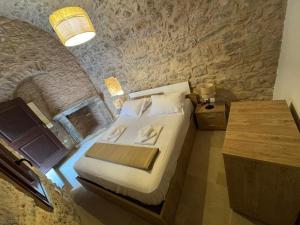 a bedroom with a bed and a stone wall at Casa Di Lithos in Mestá +7 photos