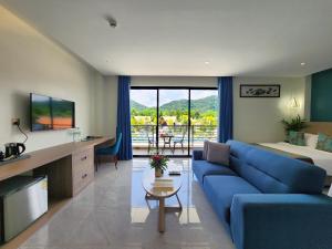 a living room with a blue couch and a table at Vakara Hotel Kep in Kep
