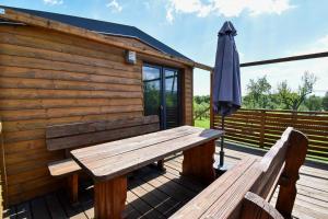 a wooden deck with two benches and an umbrella at Arktik in Bojnice