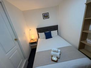 a small bedroom with a bed with a blue pillow at Hotel La Posada de los Volcanes - ALTARA in Arequipa