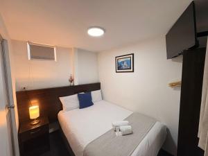 a small room with a bed and a desk with a lamp at Hotel La Posada de los Volcanes - ALTARA in Arequipa