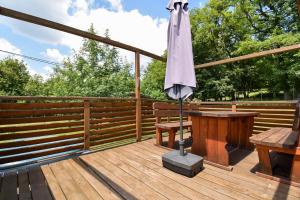 a wooden deck with a table and an umbrella at Arktik in Bojnice