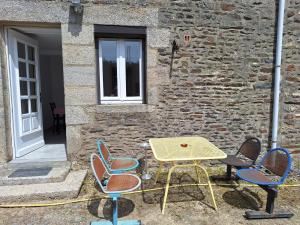 a table and chairs in front of a building at La Campanule in Saint-Cyr-en-Pail