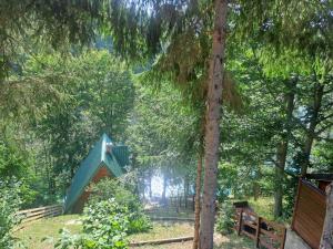 a blue bird house in a forest with a tree at Vikendica Breza 2 in Zaovine