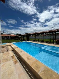 a large swimming pool with blue water at Casa Mangue in Soure