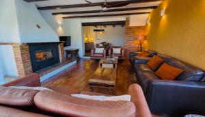 a living room with leather couches and a fireplace at Secrets Rural House in Jávea