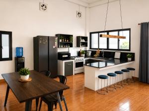 a kitchen with a wooden table and a wooden floor at Primera Vacation Home in Luang Prabang