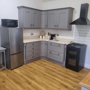 a kitchen with stainless steel appliances and wooden floors at Farm Cottage in Athy