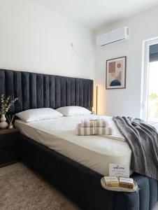 a bedroom with a large bed with a black headboard at Apartman SOFI in Ulcinj