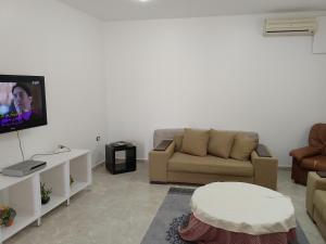 a living room with a couch and a tv at Darna in Raʼs al Jabal