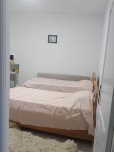 a bed in a bedroom with a white wall at Darna in Raʼs al Jabal +6 photos