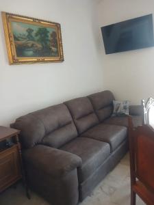 a brown couch in a living room with a picture on the wall at appartamento 4 piano in Chioggia