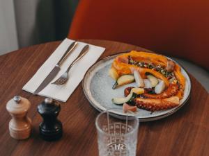 a plate of food on a table with a pretzel at Novotel Paris Vaugirard Montparnasse in Paris