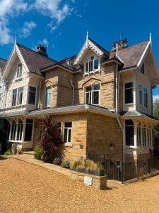 a large brick house with a fence in front of it at The Lawrance Luxury Aparthotel - Harrogate in Harrogate