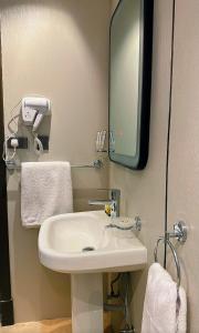 a bathroom with a white sink and a mirror at سديم الفجر للنزل السياحية بيوت عطلات وشاليهات - فئه اقتصادى in Taif